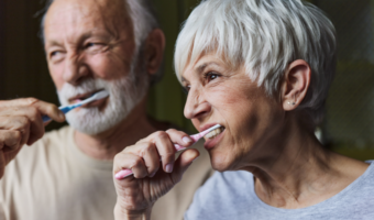 Older couple brushing their teeth together.