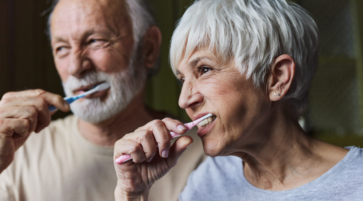 Older couple brushing their teeth together.
