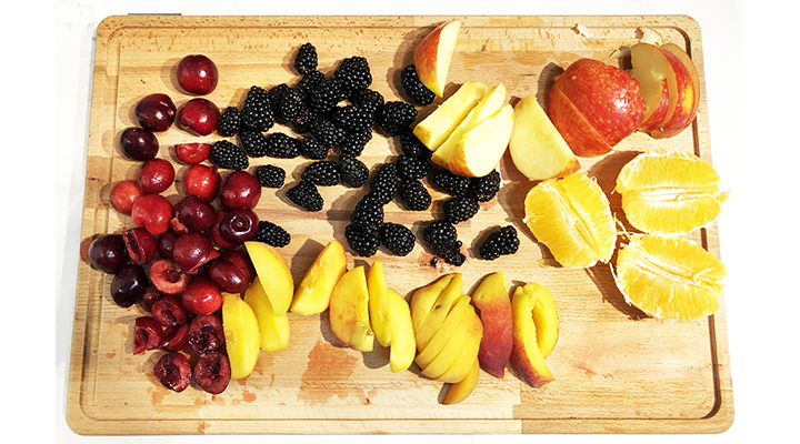 Fruit for low-sugar sangria including cherries, blackberries, apples, oranges, and peaches.