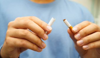 Person breaking a cigarette in half.