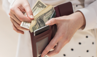 Person taking money out of their wallet.