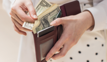 Person taking cash out of their wallet.