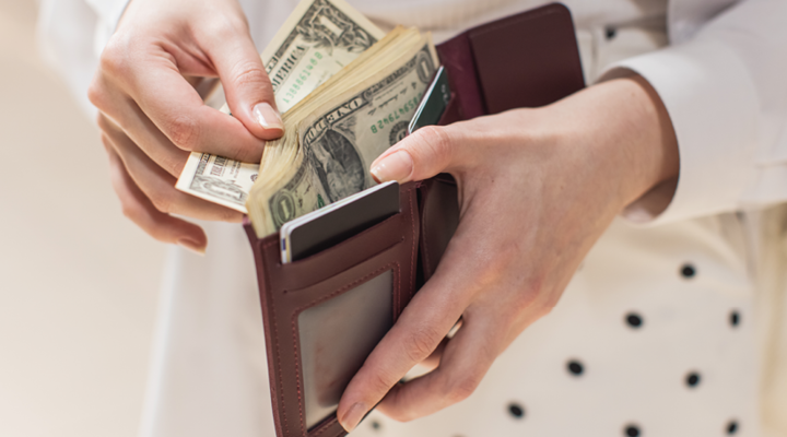 Person taking cash out of their wallet.