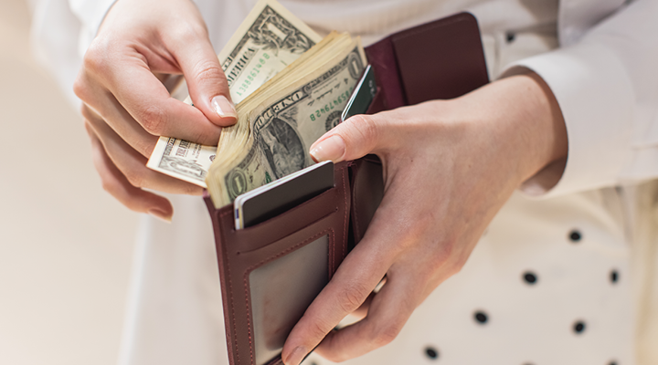 Person taking money out of their wallet.
