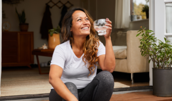 Person drinking water and smiling.