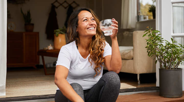 Person drinking water and smiling.