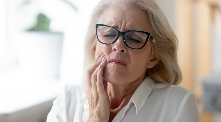 Person holding their mouth in pain.