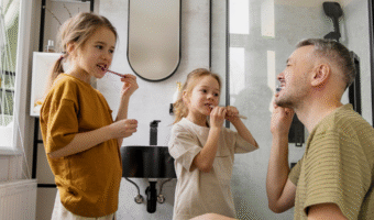 Parent and children brushing their teeth together.