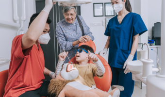 Child getting comfortable at the dentist with family.