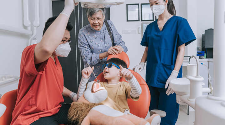 Child getting comfortable at the dentist with family.