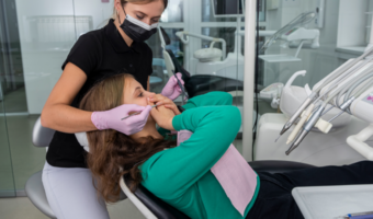 Person covering their mouth in the dental chair.