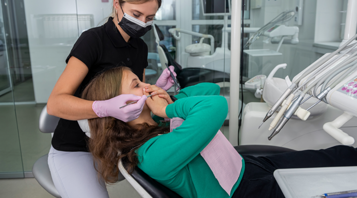 Person covering their mouth in the dental chair.
