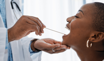 Person getting checked for oral cancer by a dentist.