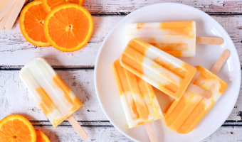 Oranges and orange creamsicles on a plate, ready to be served.