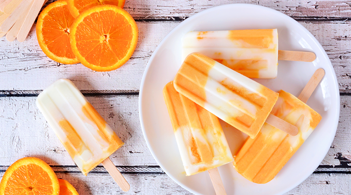 Oranges and orange creamsicles on a plate, ready to be served.