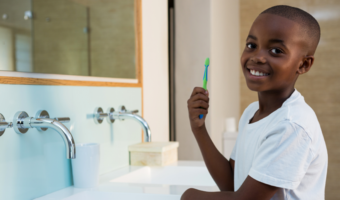 Child smiling and brushing their teeth.