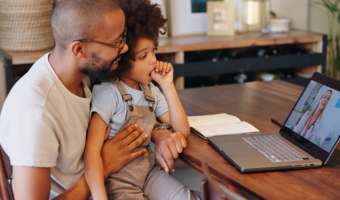 Father and son talking to their dentist on the computer.