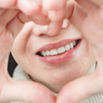 Person making a heart shape with their hands.