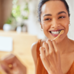 Person smiling and brushing their teeth.