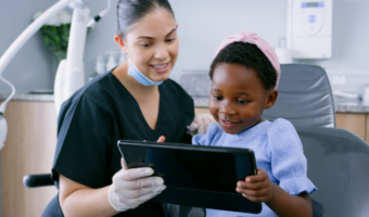 Dental assistant helping child feel comfortable at the dentist.