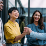 Group of employees smiling and laughing in the office.