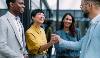 Group of employees smiling and laughing in the office.