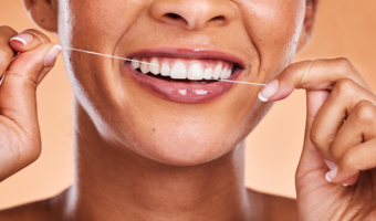 Woman smiling and flossing their teeth.