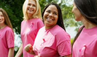 Group of women with breast cancer ribbons and pink shirts.